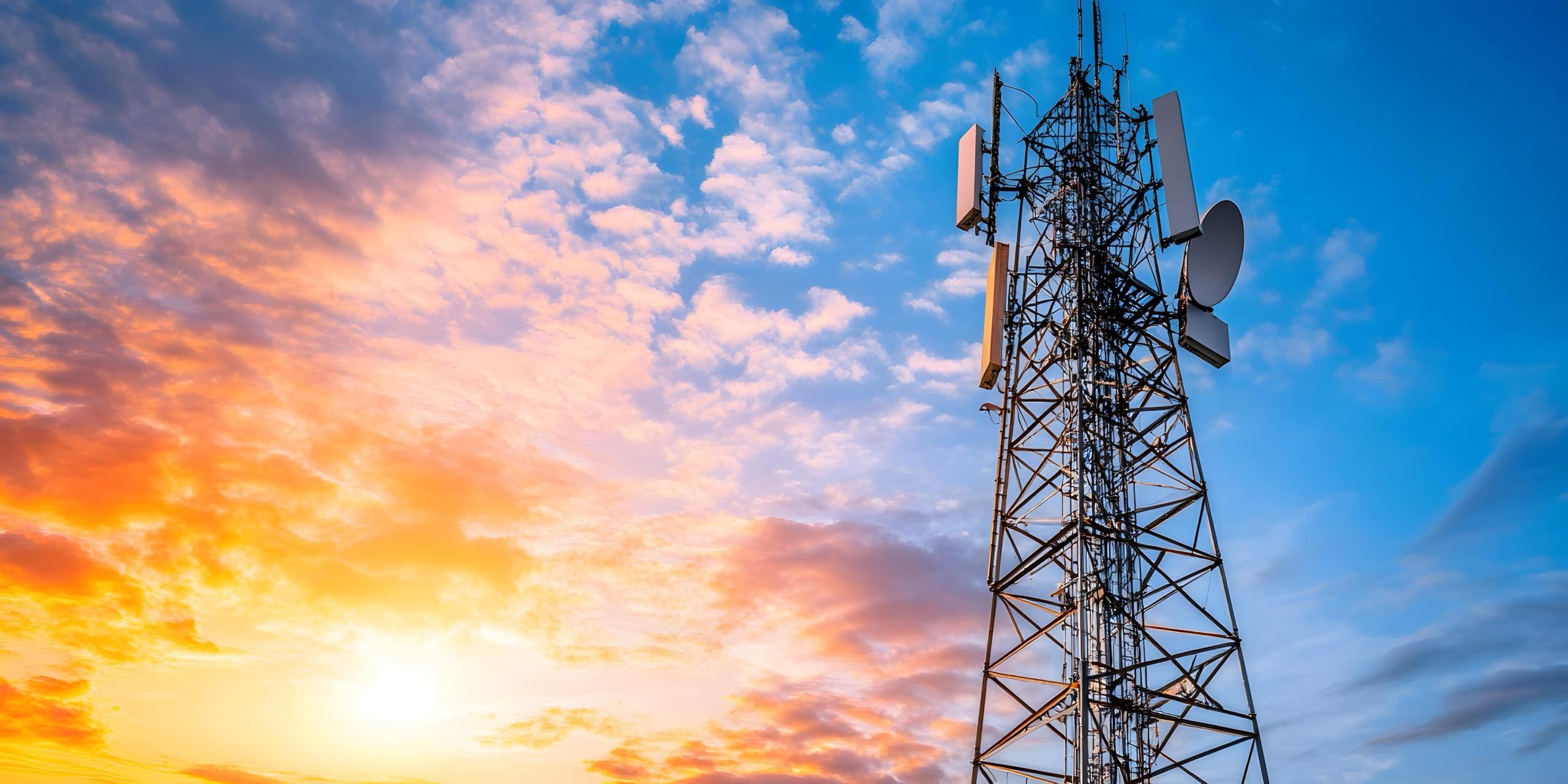 Telecommunications tower against a sunset sky